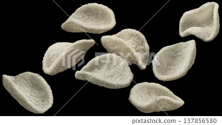 Falling japanese prawn crackers isolated on black background, traditional Asian restaurant snack, full depth of field Falling japanese prawn crackers isolated on black background, traditional Asian restaurant snack, full depth of field 137856580