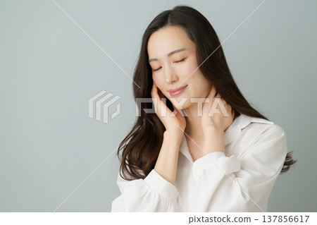 一幅年輕日本女性的肖像畫,她穿著白色襯衫,一隻手托著臉頰,雙眼緊閉,背景為灰色。 一幅年輕日本女性的肖像畫,她穿著白色襯衫,一隻手托著臉頰,雙眼緊閉,背景為灰色。 137856617