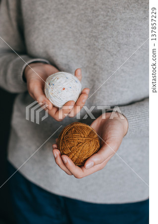 Female hands with yarn balls for knitting. Female hands with yarn balls for knitting. 137857229