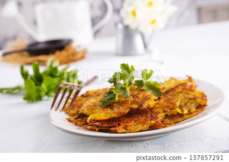 Close up view of potato pancakes. Potatoes pancakes on white plate Close up view of potato pancakes. Potatoes pancakes on white plate 137857291