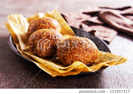 Homemade buns on a baking sheet. Delicious breakfast Homemade buns on a baking sheet. Delicious breakfast 137857317