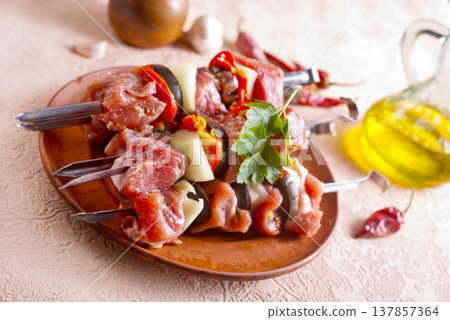 Lamb skewers on light background. Raw lamb skewer with herbs and spices. 137857364
