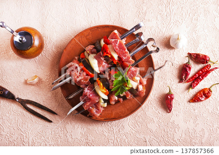 Lamb skewers on light background. Raw lamb skewer with herbs and spices. Lamb skewers on light background. Raw lamb skewer with herbs and spices. 137857366