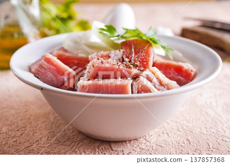 Chopped raw pork meat on a white plate on a table 137857368