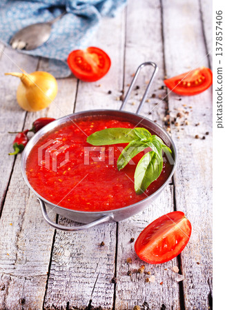 Flat lay composition with delicious tomato cream soup in bowl on white wooden table. Flat lay composition with delicious tomato cream soup in bowl on white wooden table. 137857406