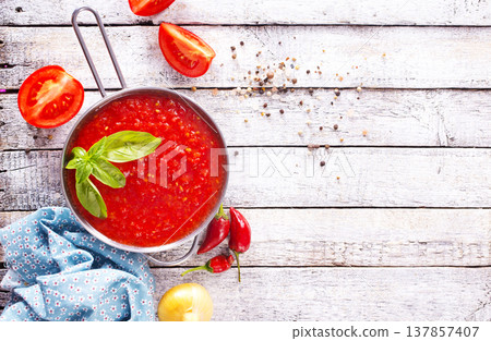 Flat lay composition with delicious tomato cream soup in bowl on white wooden table. Flat lay composition with delicious tomato cream soup in bowl on white wooden table. 137857407