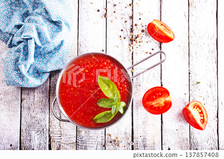 Flat lay composition with delicious tomato cream soup in bowl on white wooden table. Flat lay composition with delicious tomato cream soup in bowl on white wooden table. 137857408