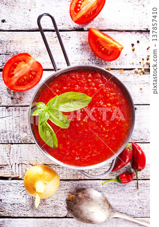 Flat lay composition with delicious tomato cream soup in bowl on white wooden table. Flat lay composition with delicious tomato cream soup in bowl on white wooden table. 137857410