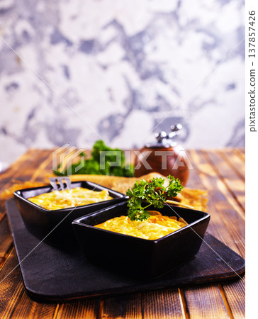 potato with cheese sauce in dark bowl on a table potato with cheese sauce in dark bowl on a table 137857426