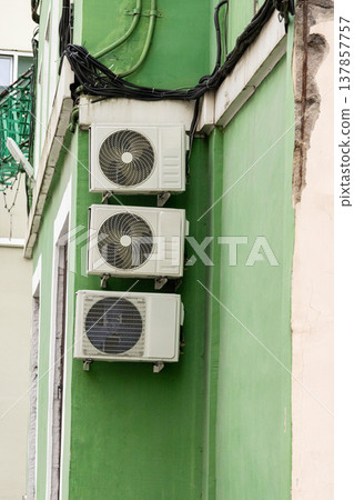 air conditioning on facade of building, air cooling in hot weather. air conditioning on facade of building, air cooling in hot weather. 137857757