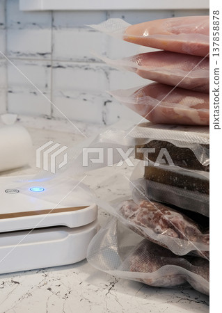 Home vacuum packer for food storage and freezing, canning products. Portions of vacuum-packed raw chicken breast, minced meat and frozen meat broth for cooking and souping. Home vacuum packer for food storage and freezing, canning products. Portions of vacuum-packed raw chicken breast, minced meat and frozen meat broth for cooking and souping. 137858878
