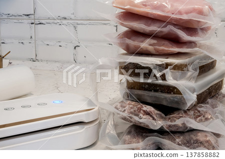 Home vacuum packer for food storage and freezing, canning products. Portions of vacuum-packed raw chicken breast, minced meat and frozen meat broth for cooking and souping. Home vacuum packer for food storage and freezing, canning products. Portions of vacuum-packed raw chicken breast, minced meat and frozen meat broth for cooking and souping. 137858882