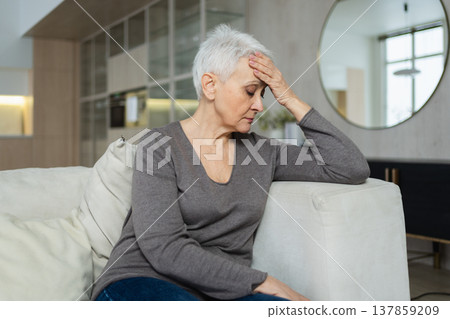 Sad tired ill sick lonely disappointed older senior woman sitting at home alone. Unhappy mature grandmother experiencing grief relative death bad news. Stressed elder lady suffering from loneliness 137859209