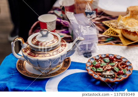 Uzbek teapot on the festive table Nauryz. hot drink on the holiday of friendship of peoples Uzbek teapot on the festive table Nauryz. hot drink on the holiday of friendship of peoples 137859349