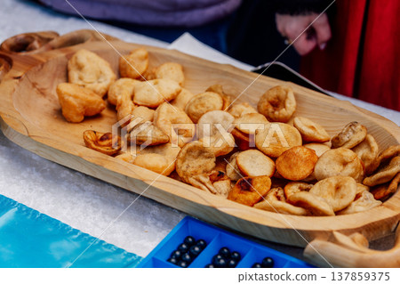 Kazakh baursaks in wooden national dishes. fried dough for the holiday Nauryz Kazakh baursaks in wooden national dishes. fried dough for the holiday Nauryz 137859375