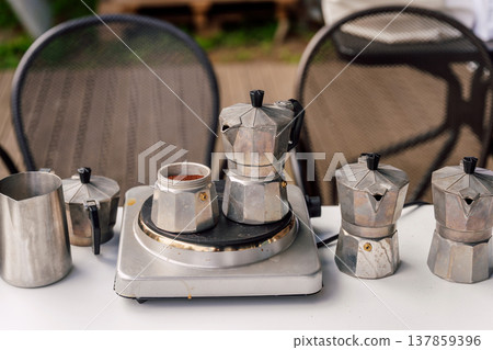 Casual Morning Coffee Ritual Outdoors. Relaxed Backyard Setup With Coffee And Rustic Elements Casual Morning Coffee Ritual Outdoors. Relaxed Backyard Setup With Coffee And Rustic Elements 137859396