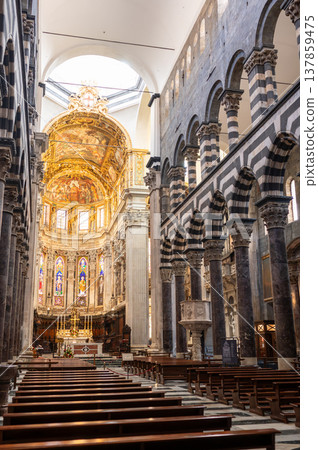 Genoa, liguria, italy. May 18, 2024. Cathedral of san lorenzo showing rows of pews facing the ornate altar, with striped marble columns and archways defining the aisle Genoa, liguria, italy. May 18, 2024. Cathedral of san lorenzo showing rows of pews facing the ornate altar, with striped marble columns and archways defining the aisle 137859475