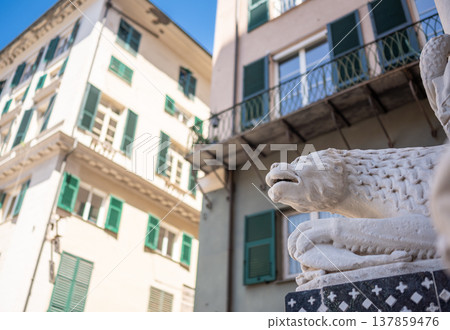Genoa, liguria, italy. May 18, 2024. Lion sculpture decorating the entry of the historic san lorenzo cathedral in genoa, italy, with ancient buildings in background 137859476