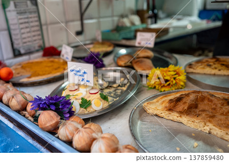 Various traditional ligurian savory pastries, focaccia, and fresh gateau di tonno on display at a local market stall promoting regional italian street food and cuisine Various traditional ligurian savory pastries, focaccia, and fresh gateau di tonno on display at a local market stall promoting regional italian street food and cuisine 137859480