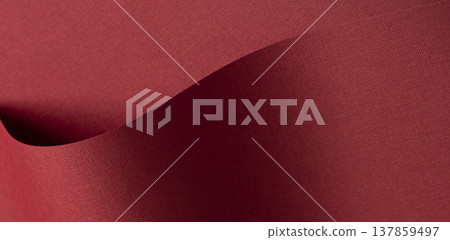 Woven fabric texture in deep burgundy and wine tones fills the background. Soft matte textile 137859497