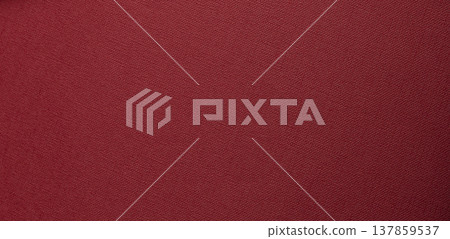 deep red textured background with flat surface. Fine woven grain and matte tactile material create a 137859537