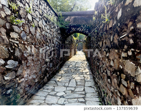 Narrow stone corridor with arched passageways inside Amber Fort in Jaipur. Historic fortress walkway 137859639