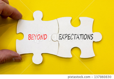 Beyond expectations words symbol. Concept words Beyond expectations on beautiful white puzzles. Beautiful yellow background. Businessman hand. Business Beyond expectations words concept. Copy space. 137860830