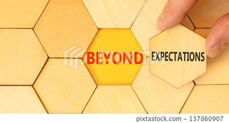Beyond expectations words symbol. Concept words Beyond expectations on beautiful wooden puzzles. Beautiful yellow background. Businessman hand. Business Beyond expectations words concept. Copy space. 137860907