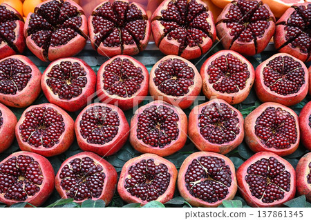 Rows of ripe pomegranates with bright ruby-red seeds 137861345