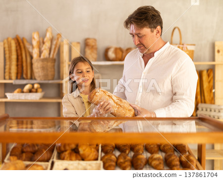 Father and little daughter choosing fresh bread from bakery display Father and little daughter choosing fresh bread from bakery display 137861704
