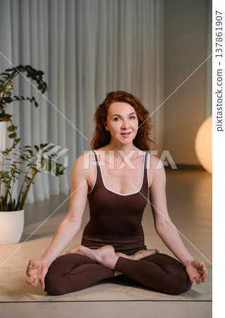 Woman practices yoga in a bright room with plants during afternoon light focusing on mindfulness and relaxation techniques Woman practices yoga in a bright room with plants during afternoon light focusing on mindfulness and relaxation techniques 137861907