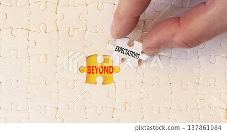 Beyond expectations words symbol. Concept words Beyond expectations on beautiful white puzzles. Beautiful yellow background. Businessman hand. Business Beyond expectations words concept. Copy space. 137861984