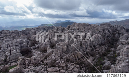 Majestic Limestone Formations in El Torcal's Karst Landscape Explore rugged cliffs and weathered terrain under a dramatic cloudy sky. perfect backdrop for nature and geology-themed projects.Limestone 137862129