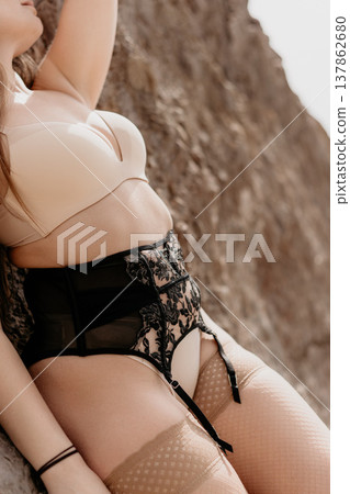 Lingerie body stockings Sensual woman wearing lace garter belt leaning against a textured rock wall outdoors copy space Lingerie body stockings Sensual woman wearing lace garter belt leaning against a textured rock wall outdoors copy space 137862680