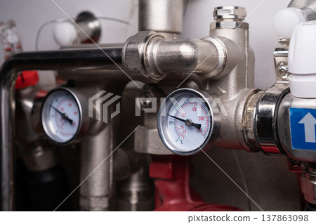 Complex residential heating manifold system with valves, gauges, and piping network Complex residential heating manifold system with valves, gauges, and piping network 137863098