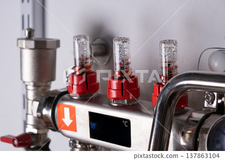 Complex residential heating manifold system with valves, gauges, and piping network Complex residential heating manifold system with valves, gauges, and piping network 137863104
