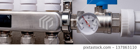 Complex residential heating manifold system with valves, gauges, and piping network. banner Complex residential heating manifold system with valves, gauges, and piping network. banner 137863110