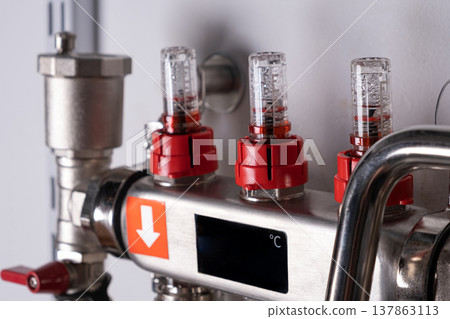 Complex residential heating manifold system with valves, gauges, and piping network. banner Complex residential heating manifold system with valves, gauges, and piping network. banner 137863113