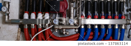 Complex residential heating manifold system with valves, gauges, and piping network. banner Complex residential heating manifold system with valves, gauges, and piping network. banner 137863114
