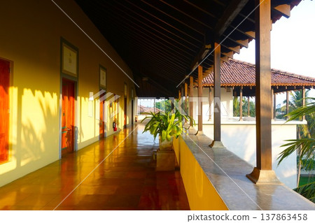 A classic corridor of a resort hotel bathed in the setting sun. 137863458