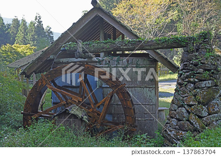 A charming, unspoiled landscape unfolds in Uchiko Town, Ehime Prefecture, with a traditional watermill standing amidst the lush, green countryside of Ishidatami Seiryuen. A charming, unspoiled landscape unfolds in Uchiko Town, Ehime Prefecture, with a traditional watermill standing amidst the lush, green countryside of Ishidatami Seiryuen. 137863704