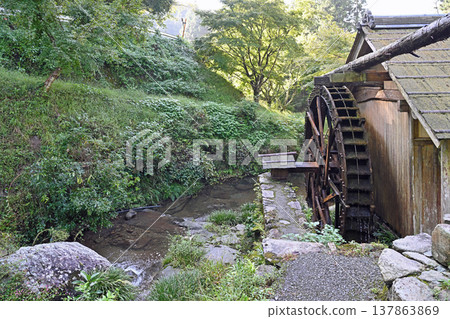 A tranquil watermill scene at Ishidatami Seiryuen in Uchiko Town, Ehime Prefecture: A pristine mountain village landscape woven together by the clear flow of the river and a wooden watermill. A tranquil watermill scene at Ishidatami Seiryuen in Uchiko Town, Ehime Prefecture: A pristine mountain village landscape woven together by the clear flow of the river and a wooden watermill. 137863869