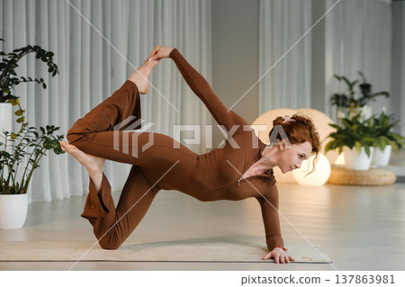 Yoga practice in a bright studio with plants and soft lighting 137863981