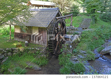 The tranquil scenery of Ishidatami Seiryuen in Uchiko Town, Ehime Prefecture: A pristine mountain village landscape woven together by a cedar bark-roofed watermill and a clear stream. The tranquil scenery of Ishidatami Seiryuen in Uchiko Town, Ehime Prefecture: A pristine mountain village landscape woven together by a cedar bark-roofed watermill and a clear stream. 137864121