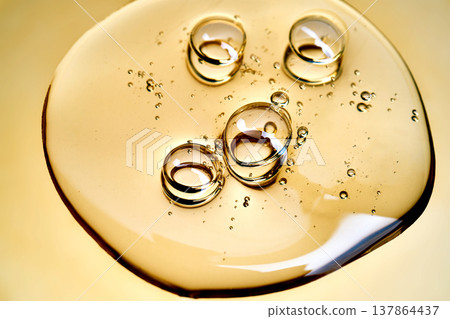 Golden transparent gel flowing with bubbling texture Golden transparent gel flowing with bubbling texture 137864437