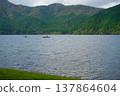 Fishing boats sailing on Lake Ashi in Hakone, surrounded by lush green mountains. 137864604