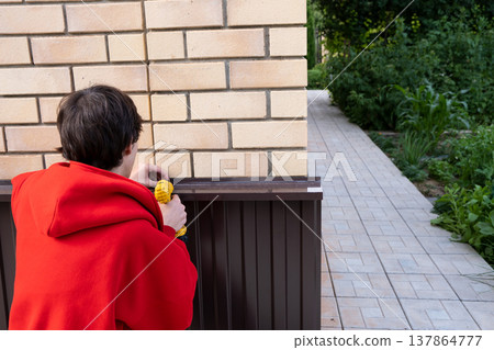 Worker installing house plinth with metal sheets during construction works 137864777