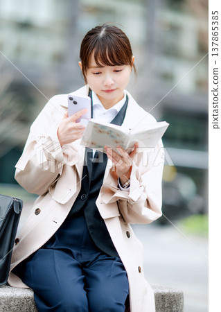 一位年輕的女商人正在街頭用手機打電話。 一位年輕的女商人正在街頭用手機打電話。 137865385