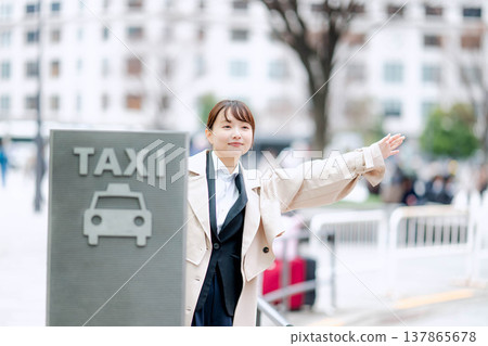A young businesswoman waiting for a taxi in the city. A young businesswoman waiting for a taxi in the city. 137865678
