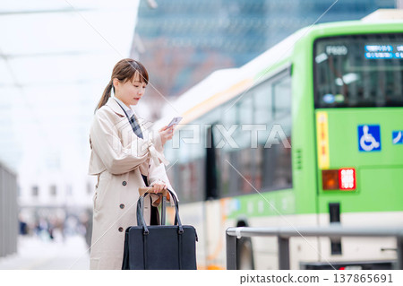 一位年輕的女商人正在城市裡等計程車。 一位年輕的女商人正在城市裡等計程車。 137865691